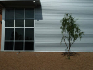 Grey house with bush